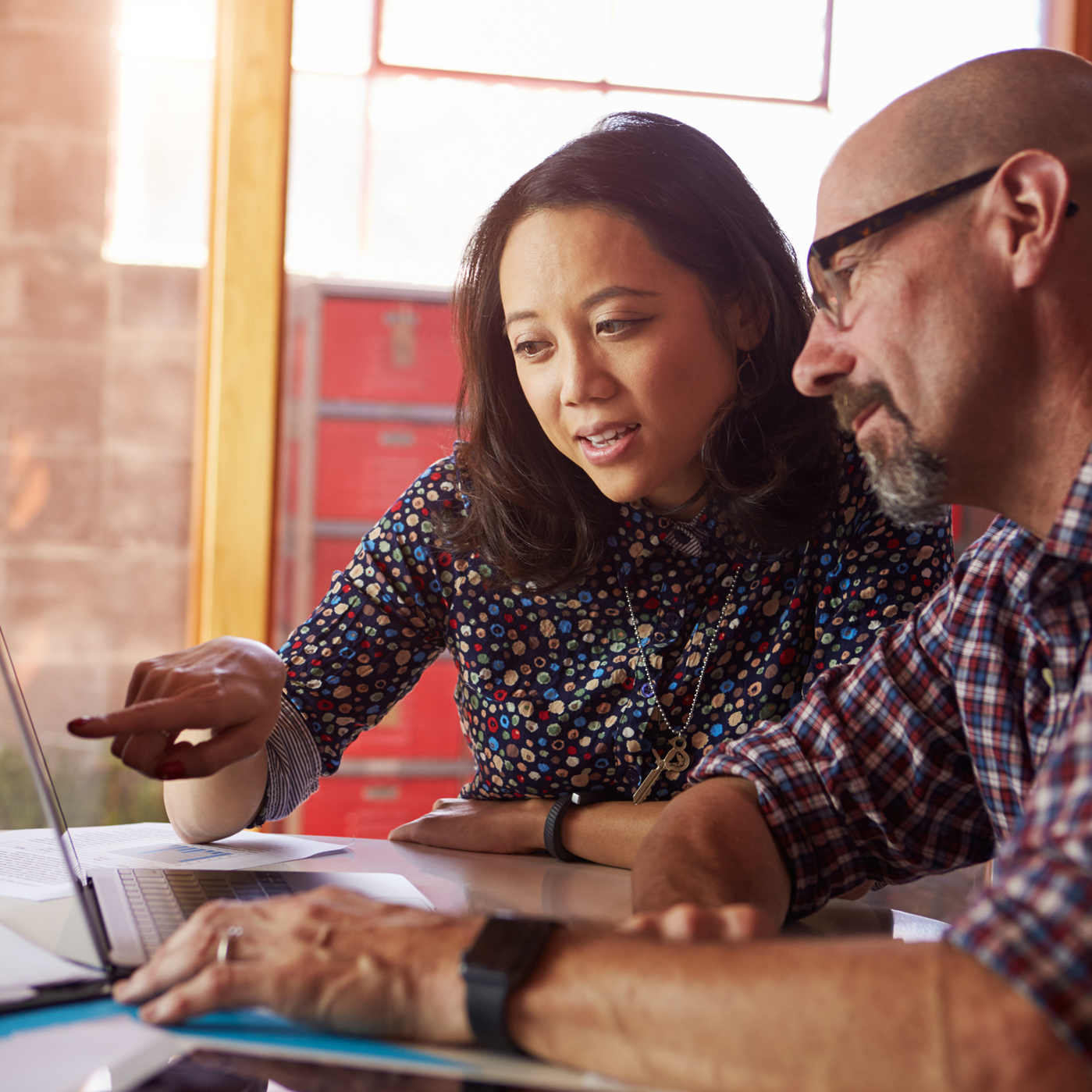 Woman pointing to laptop and discussing worker's comp claims with psychologist