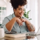 Woman with laptop in living room attending telehealth psychology session