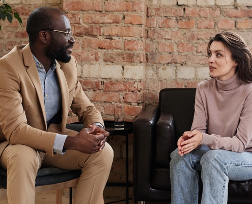 Two people sitting down on sofas holding a conversation busting pychology myths