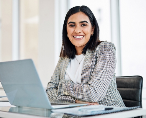 Smiling female office worker at desk how can EAPs help employees