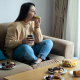 Woman eating sugary food on sofa eating disorders concept image
