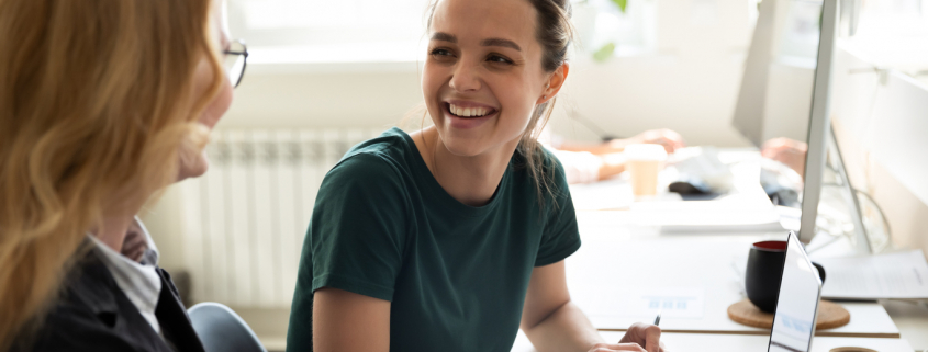 Two women at a desk creating workplace mental health policy