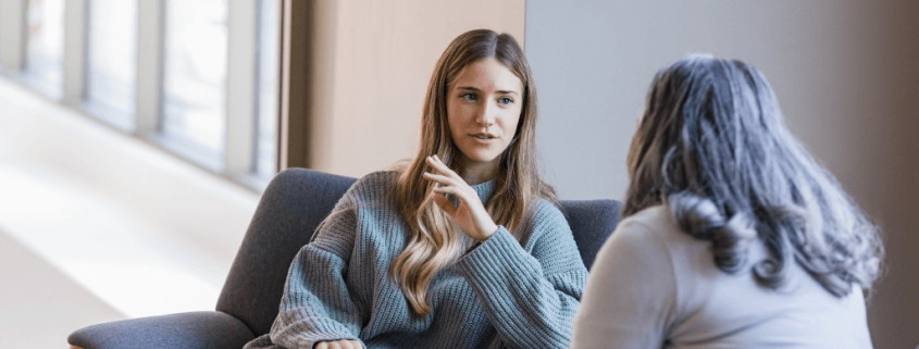 Woman in wooly jumper talking to mental health psychologist