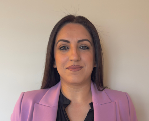 Professional headshot image of a woman wearing a pink jacket