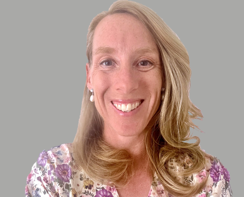 Professional headshot of smiling woman against a plain grey background, Kate Robinson