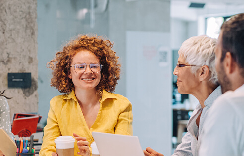 A diverse group of people in a professional setting, smiling at each other