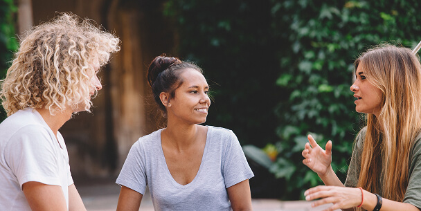 Three women smiling and talking together