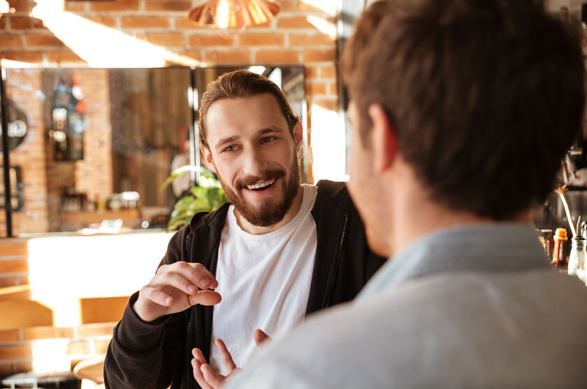 Two men smiling and talking