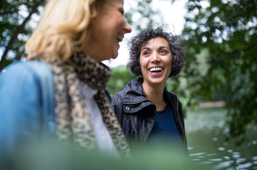 Two women walking and smiling in conversation
